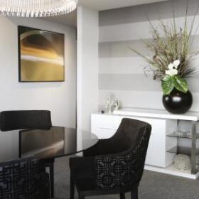 Southbank Apartment by Lewisham Interiors – compact modern dining space with bold striped wallpaper, floral styling, and monochrome palette